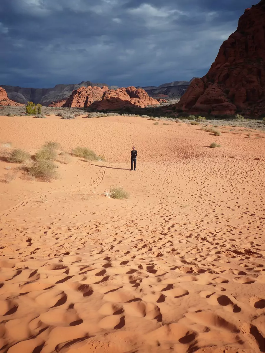A person standing in the sand at Snow Canyon State Park.
