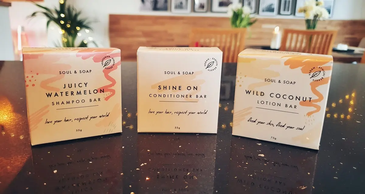 A selection of solid shampoos and hair products in cardboard containers on a kitchen counter.
