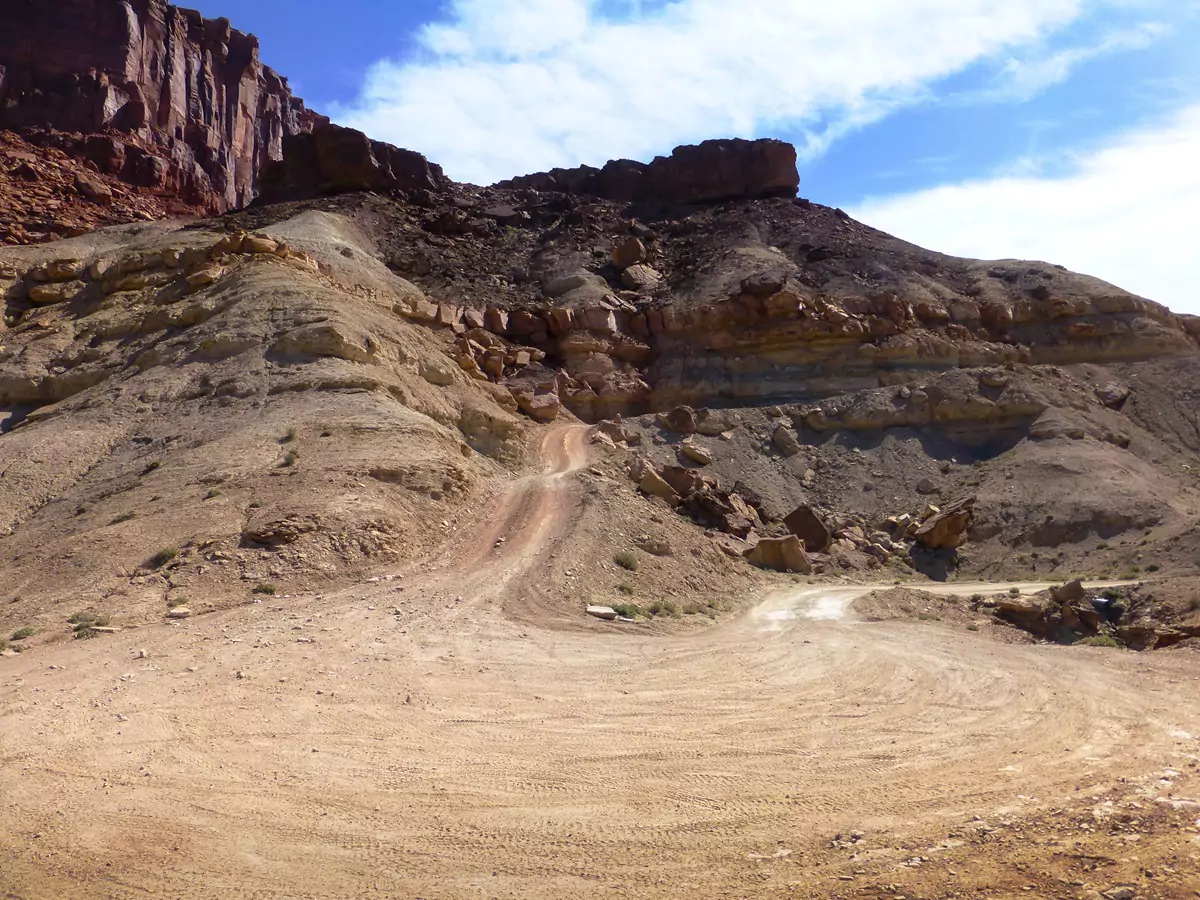 A steep ascending right-hand turn along a rough section of the White Rim Road known as Hardscrabble.