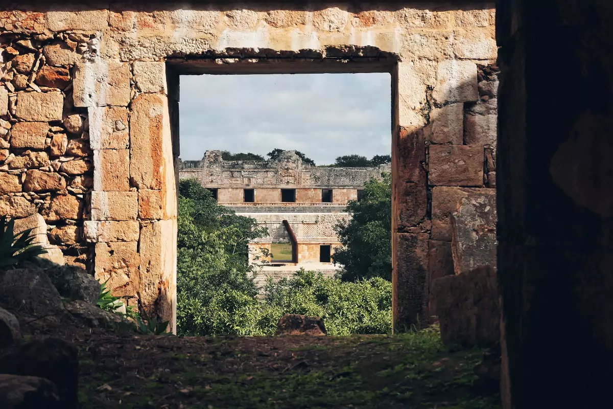 View of the Quadrangle at Uxmal through the doorway of one of the structures there, showing off the architectural style.