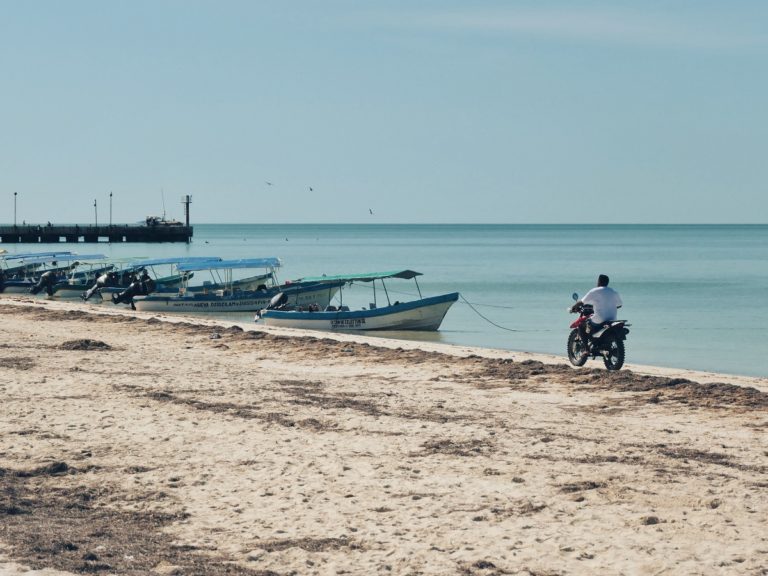 A man riding a motorcycle by the sea