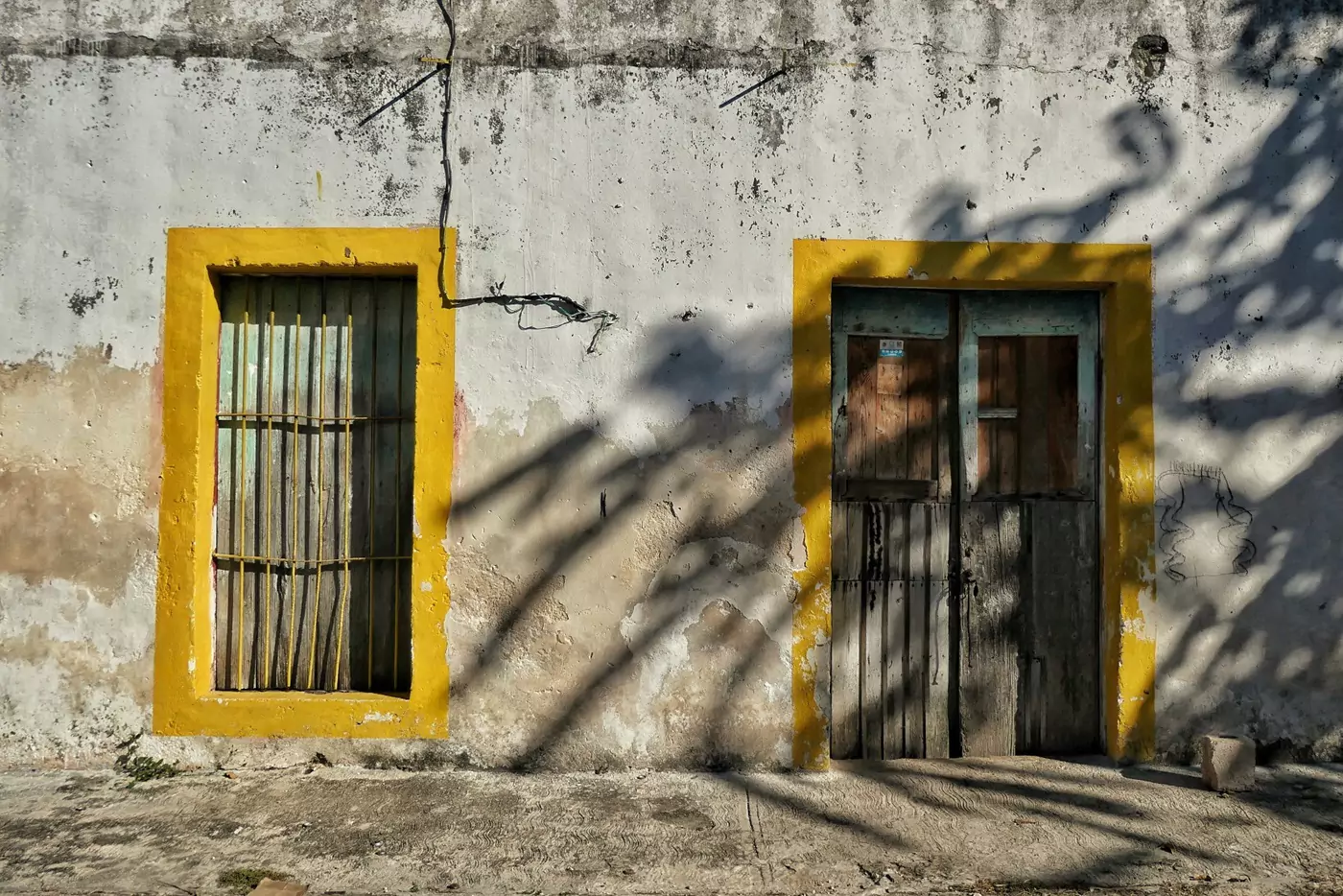 Painted yellow lines around a door and window frame on a house in Merida.