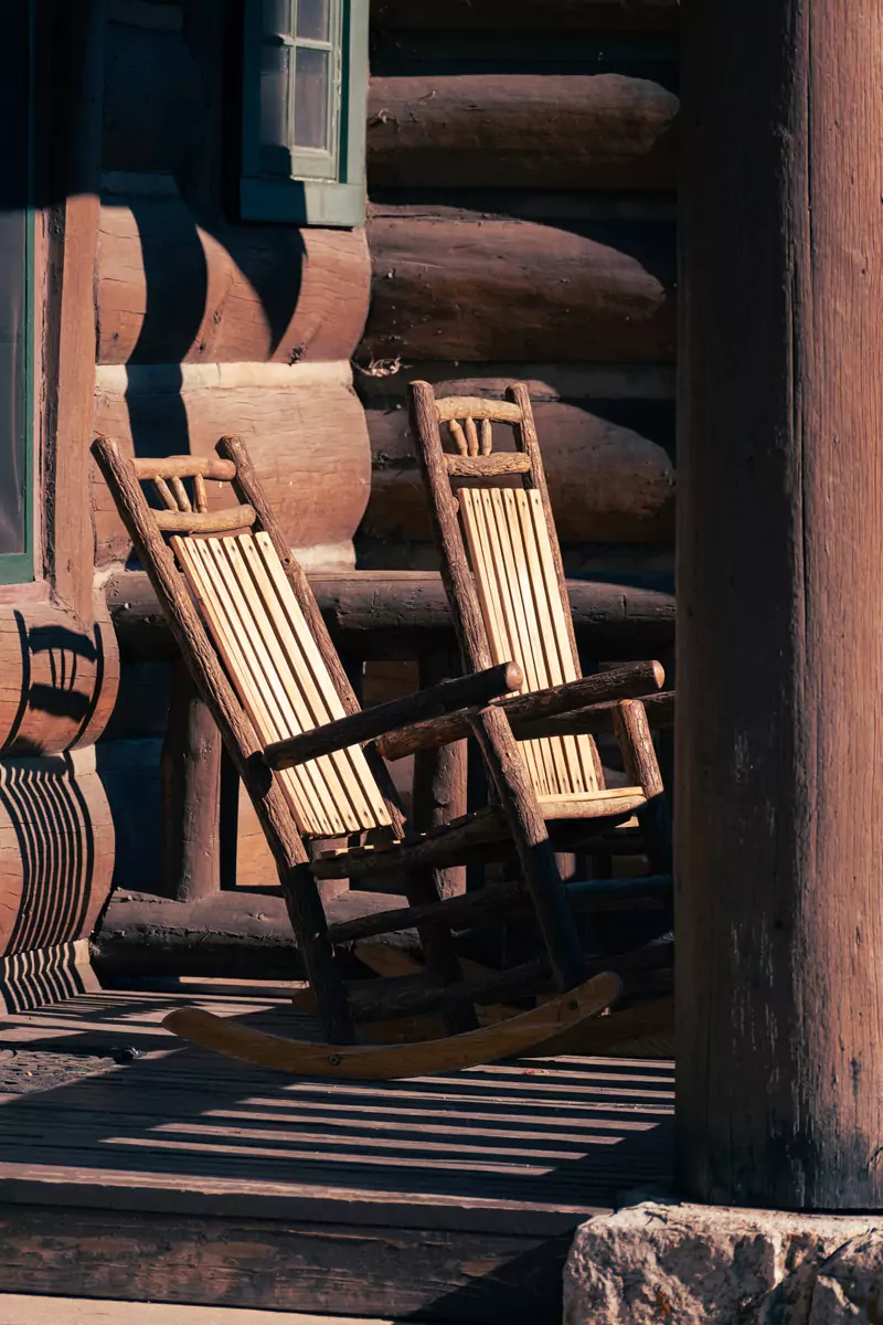 Two wooden rocking chairs on the decking outside accommodation at the Grand Canyon Lodge.