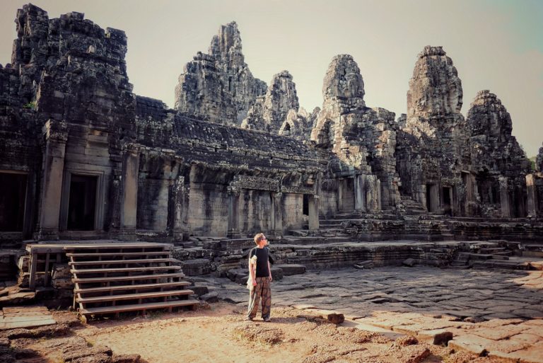 A man standing and looking at the ruins of Angkor Wat