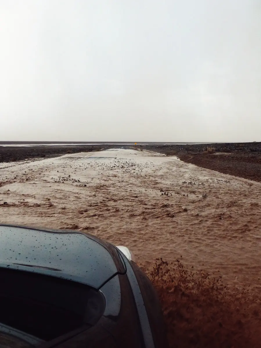 A car driving through a flooded section of road in Death Valley.