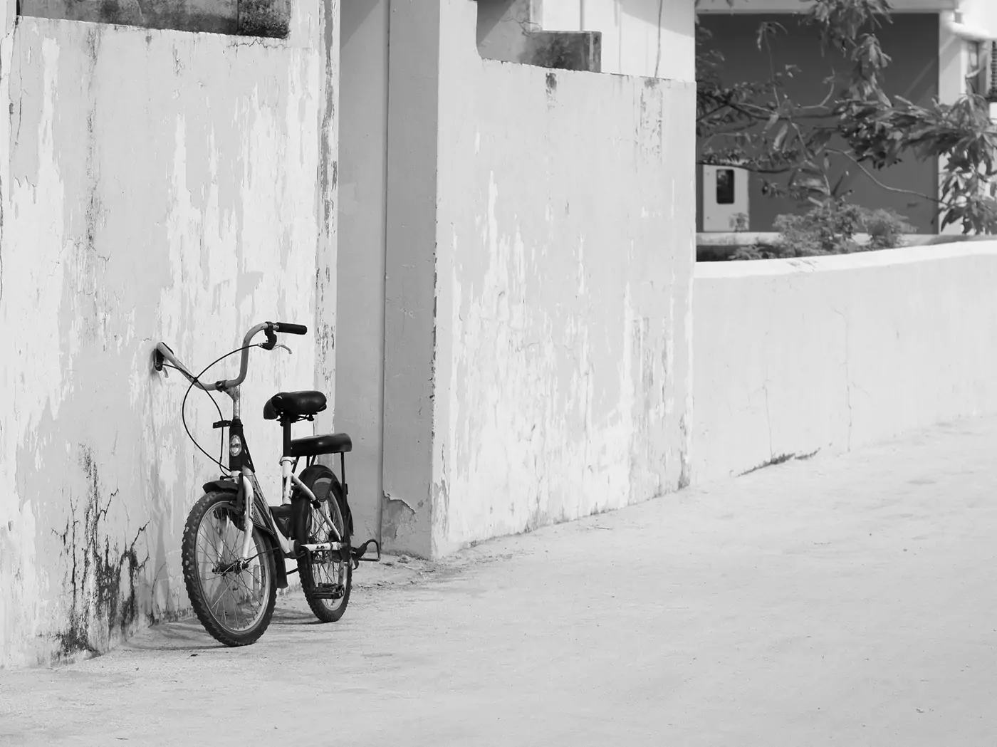 A bicycle leaning against a wall on a side street on the island of Thulusdhoo.
