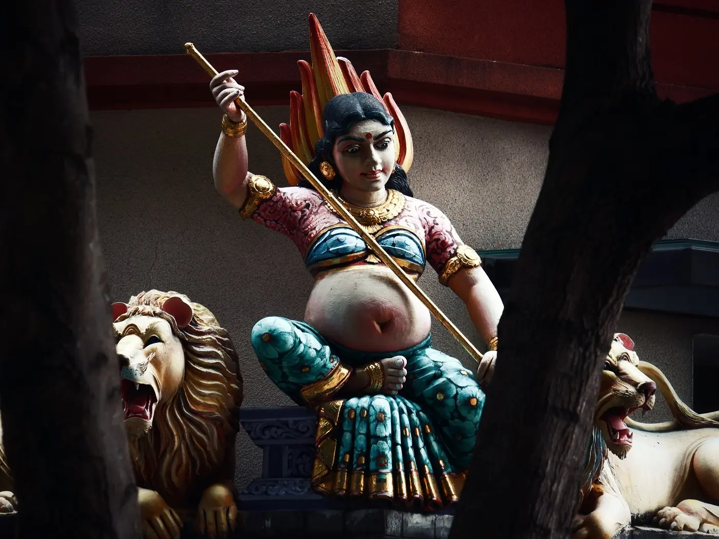 Statue of a female deity holding a spear, outside a temple in Singapore.