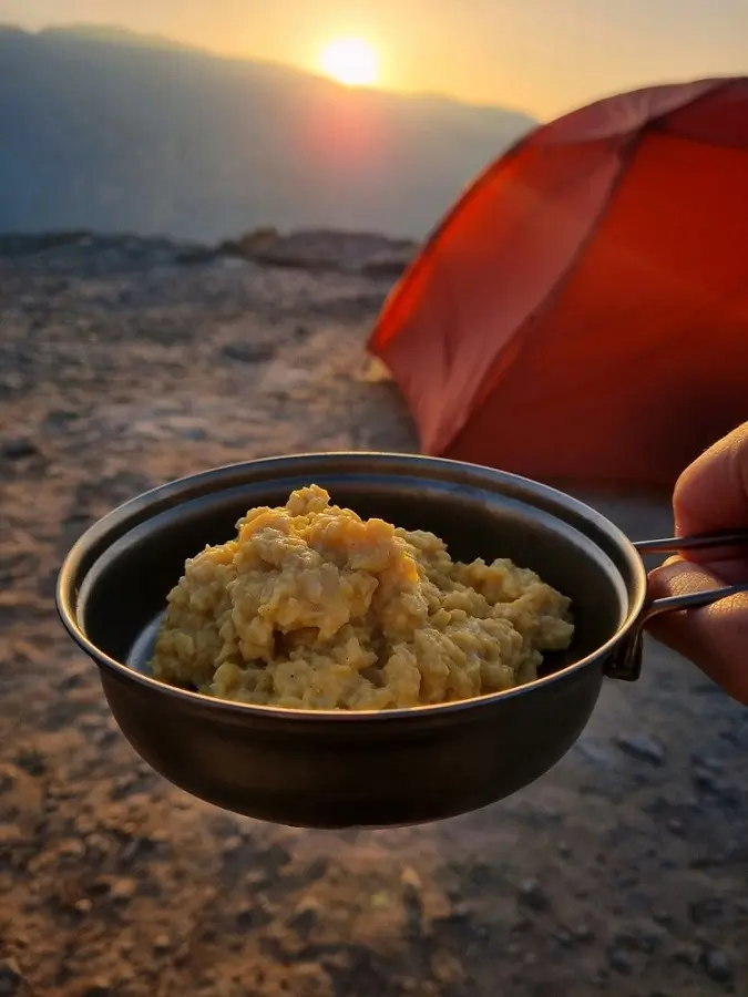 Scrambled eggs in a pan for a sunrise breakfast at a mountainside campsite in Oman.