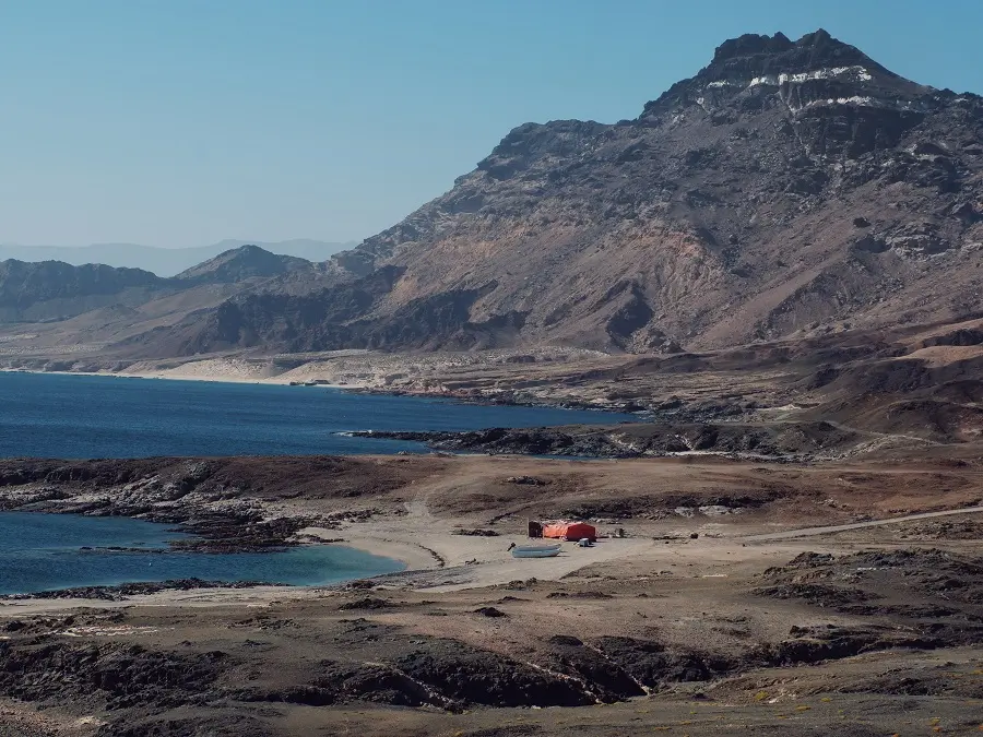 An orange fishing camp beneath the mountains along Mirbat's shore to the east of Salalah in Oman.
