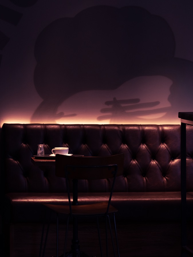 A cup of coffee sat alone on a table in a dark, cosy café in Leeds.