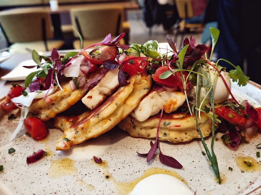A stack of sweetcorn fritters with a small dressed salad topping at Laynes Coffee, Leeds.