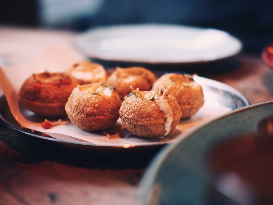 Six filled pani puri on a dish at a Leeds restaurant.