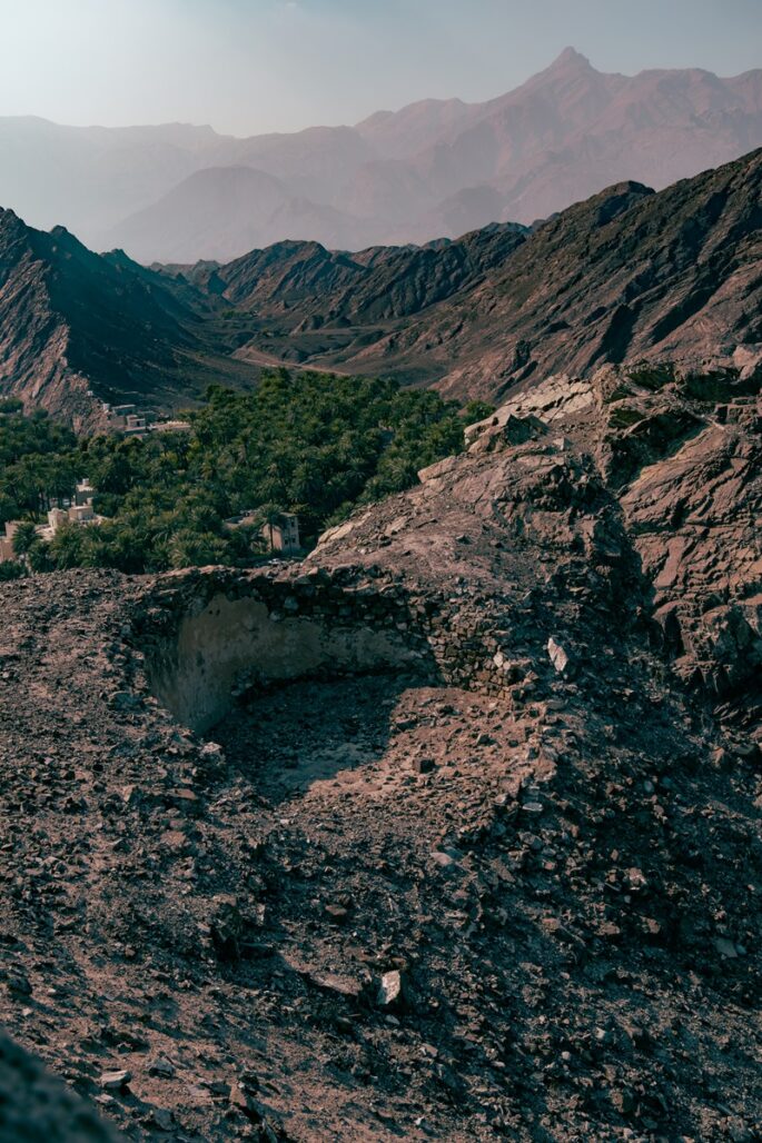 Verdant trees and buildings in wadi Samail nearby Samail Castle in Oman.