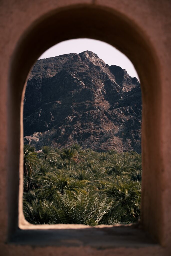 A mountainside view through an archer's window at the Omani fort of Samail.