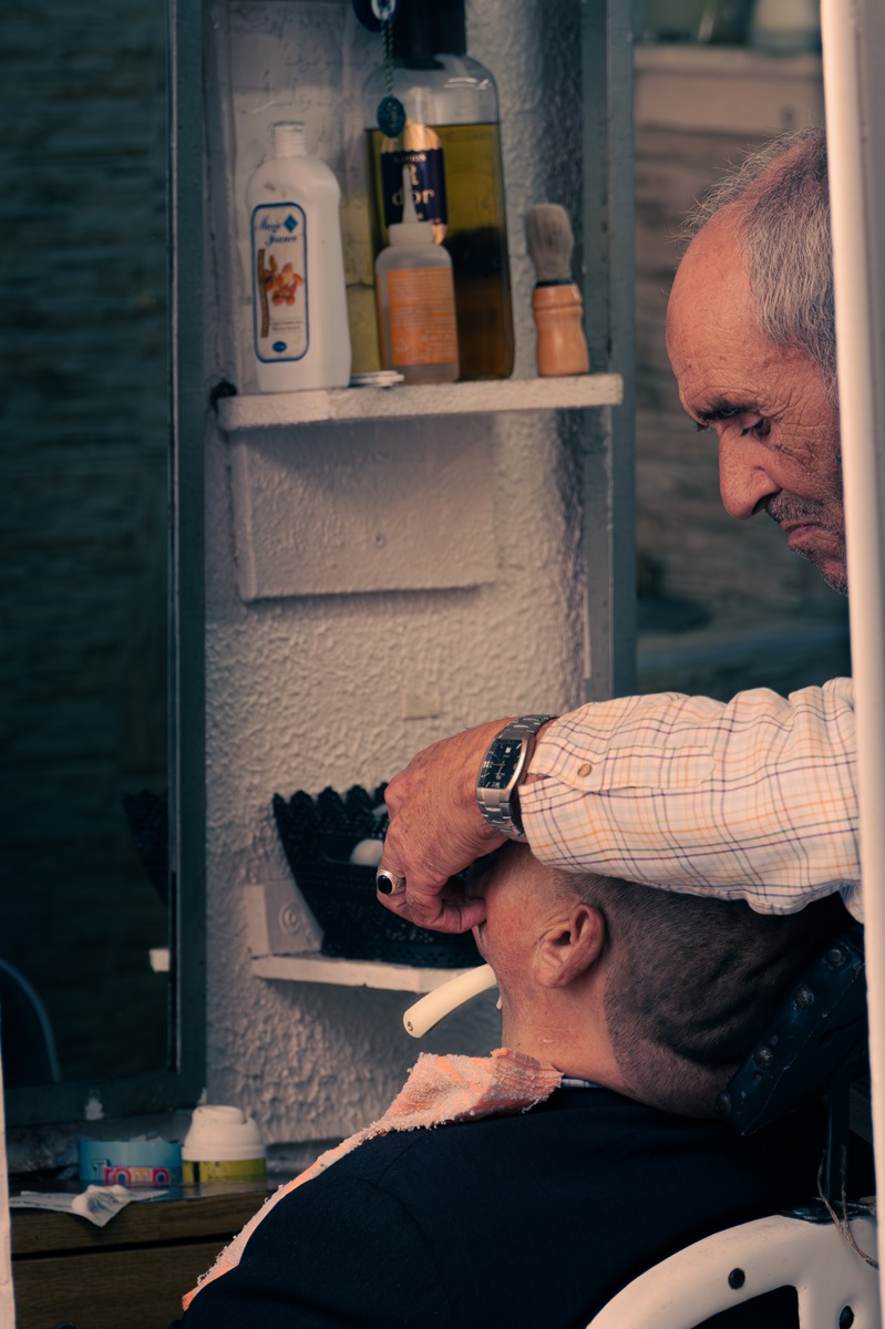 A barber in Tangier, one of the most beautiful cities in Morocco, shaving a client's face.