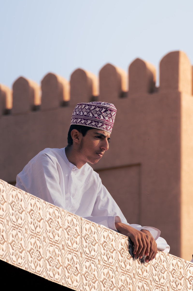A young Omani male watching from the rooftop above the Nizwa goat market.