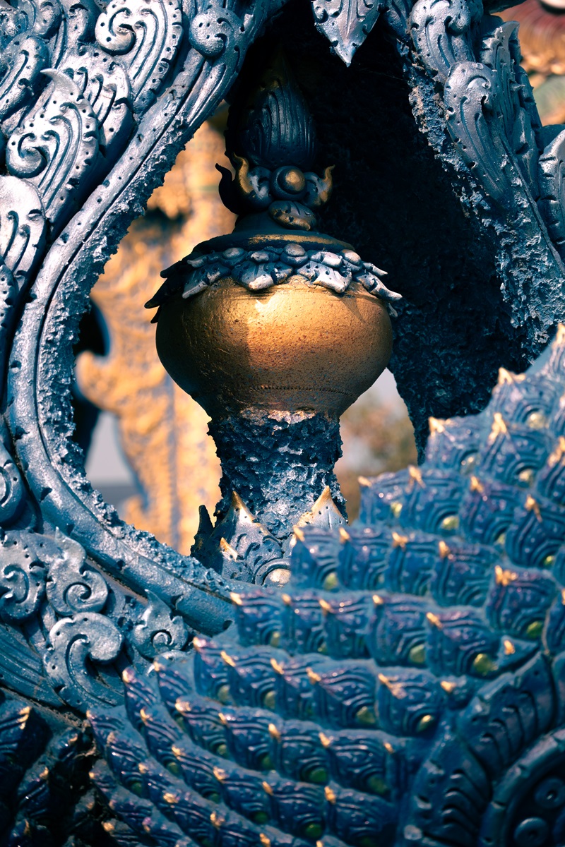 Close up of intricate details of a serpentine tail of a statue at a temple in Chiang Rai, The Blue Temple.