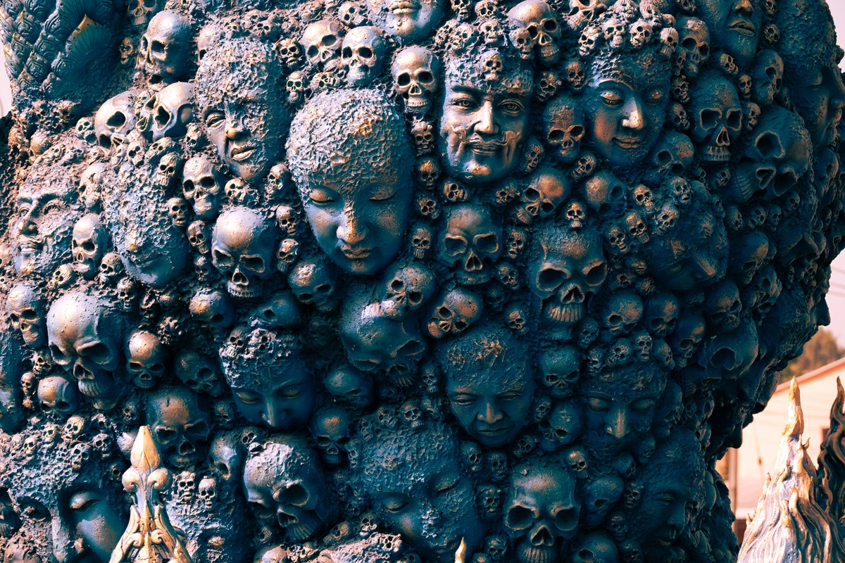 Skulls and faces in a cohesive mass of a sculpture at the Blue Temple in Thailand's Chiang Rai district.