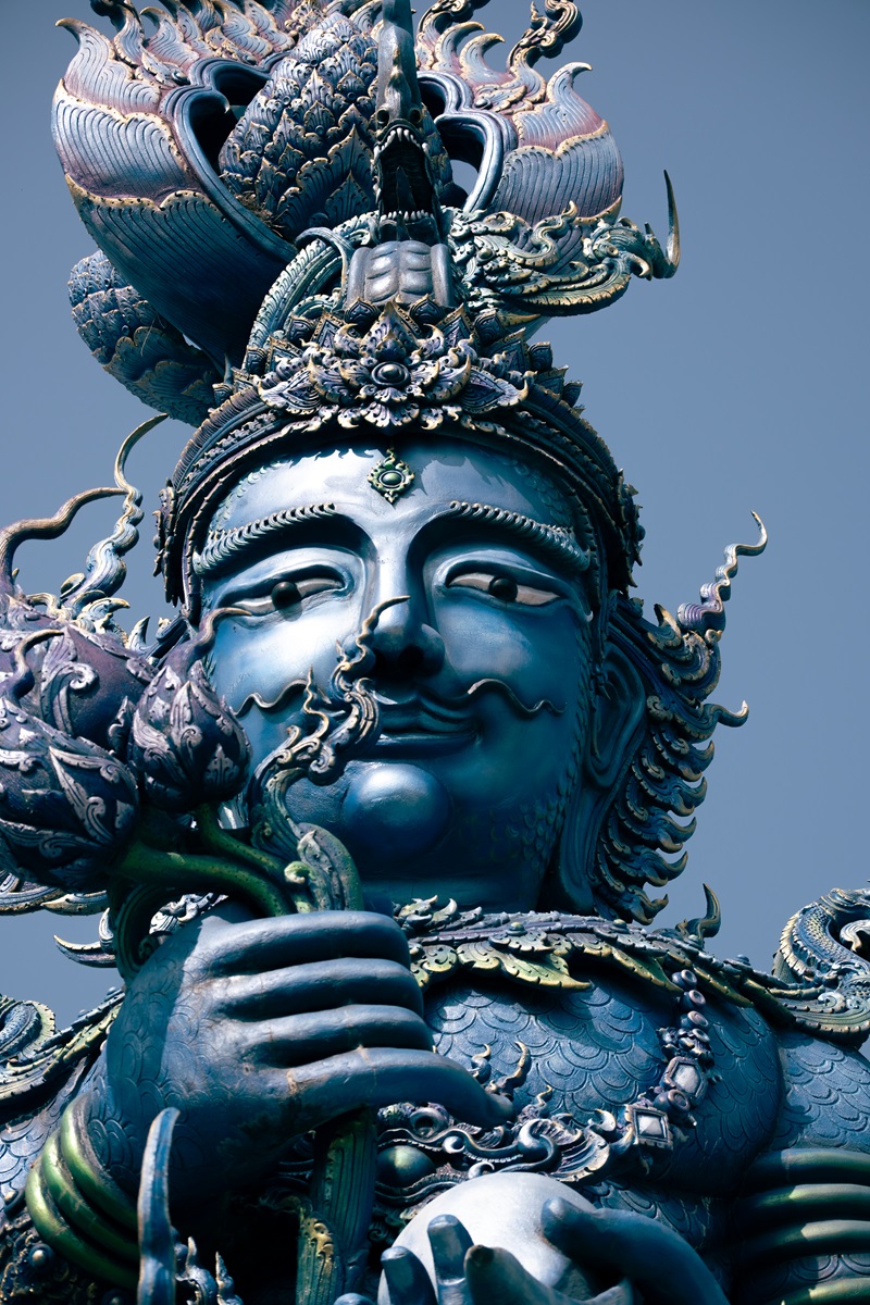 The head of one of the giant blue entrance statues at the Blue Temple in Chiang Rai.