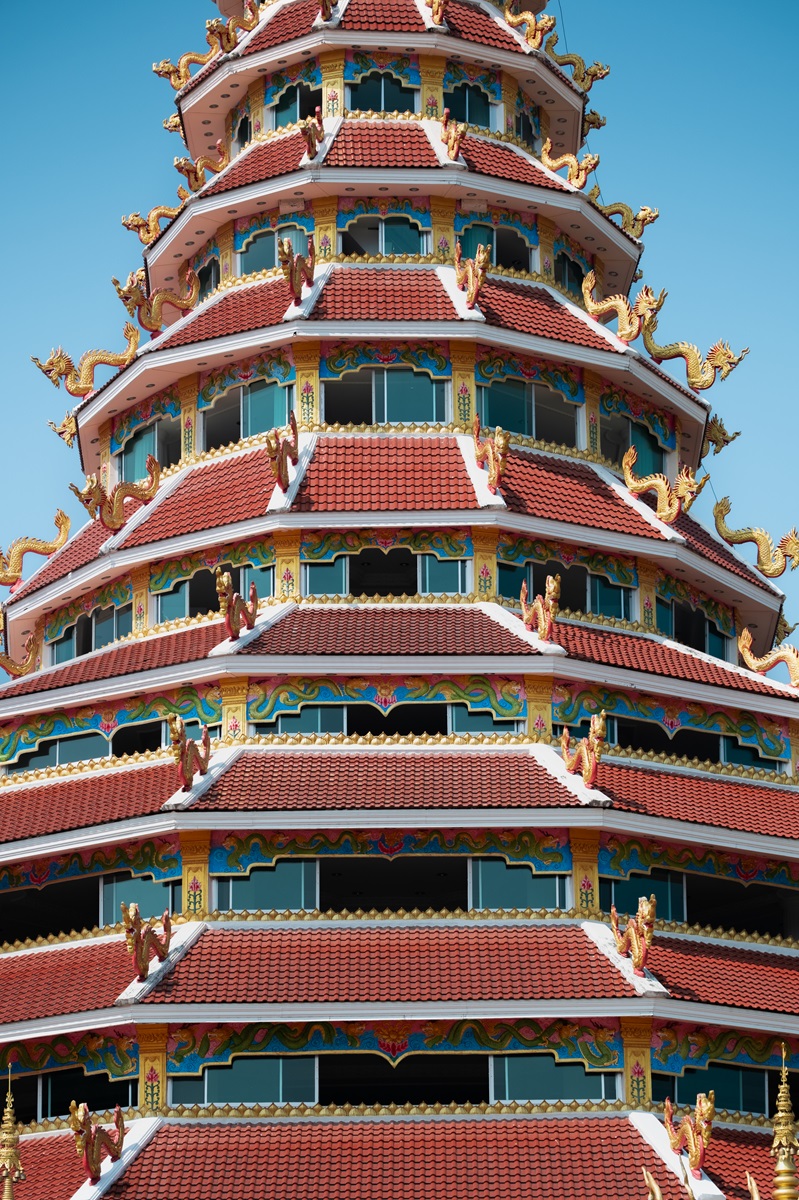 The many red storeys with golden dragon motifs of the Goddess of Mercy Pagoda north of Chiang Rai, Thailand.