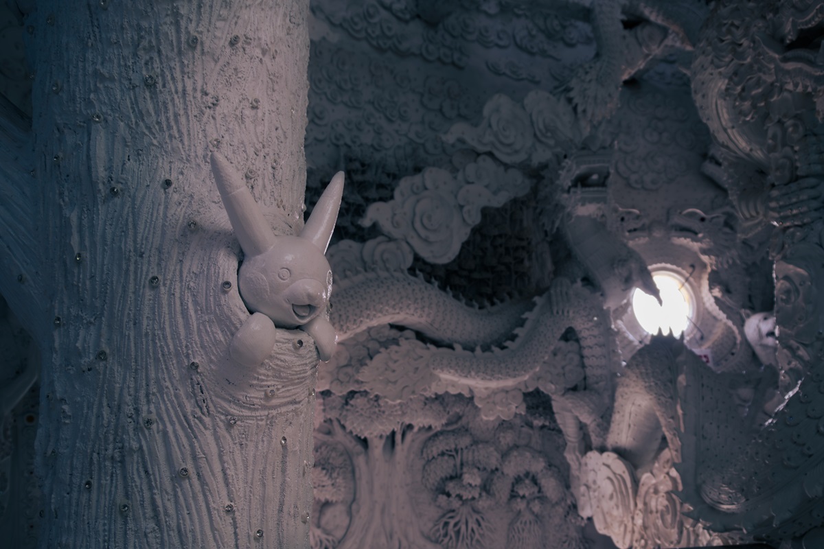 Intricately crafted scene inside the head of the Goddess of Mercy including a bunny coming out of a tree.