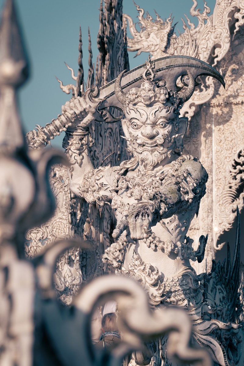 Statue of a guardian on the bridge to enter the White Temple in Chiang Rai, Thailand.