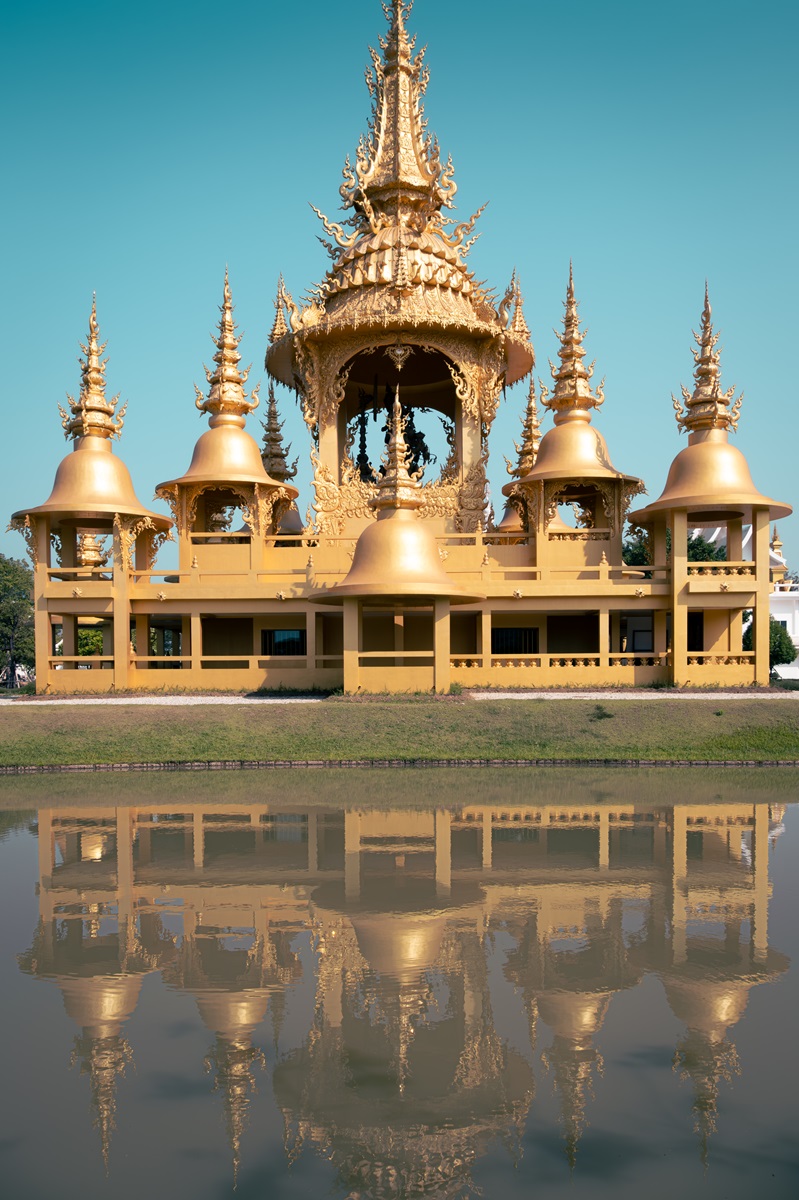 The Golden Temple at Chiang Rai, reflected in the water.