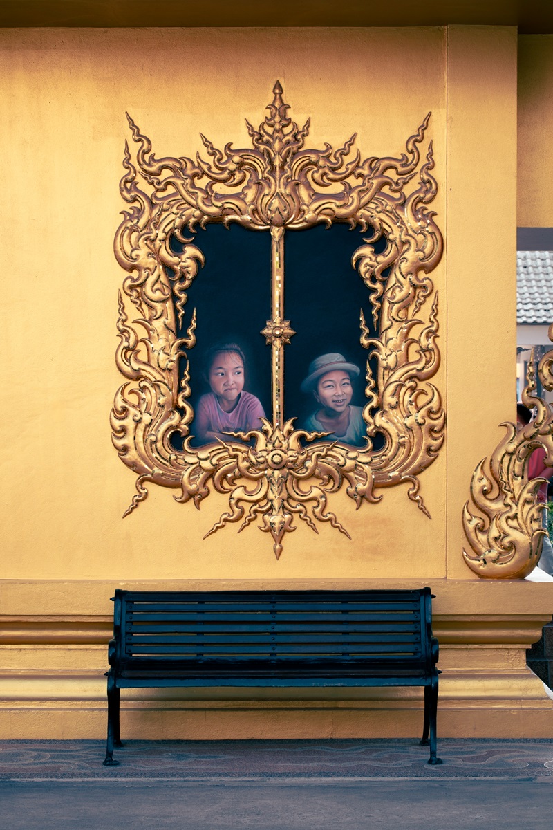 A detailed painting of children looking through a window at the White Temple in Chiang Rai.