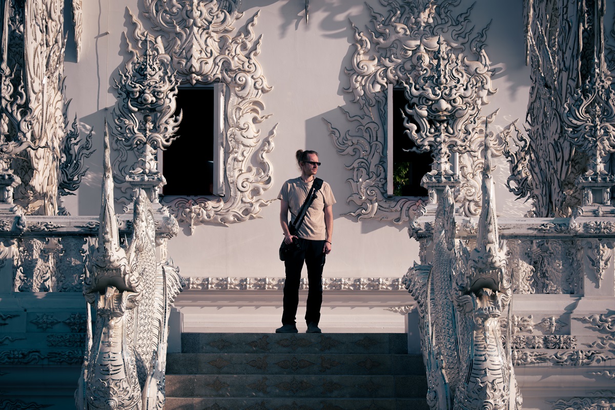 A person standing atop the stairs at the White Temple in Chiang Rai.