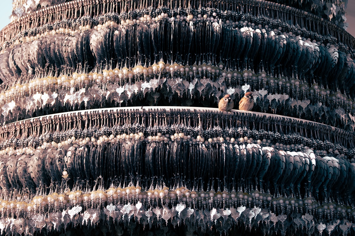 Two birds sat on an art installation of a Bodhi tree at the White Temple in Thailand's Chiang Rai.