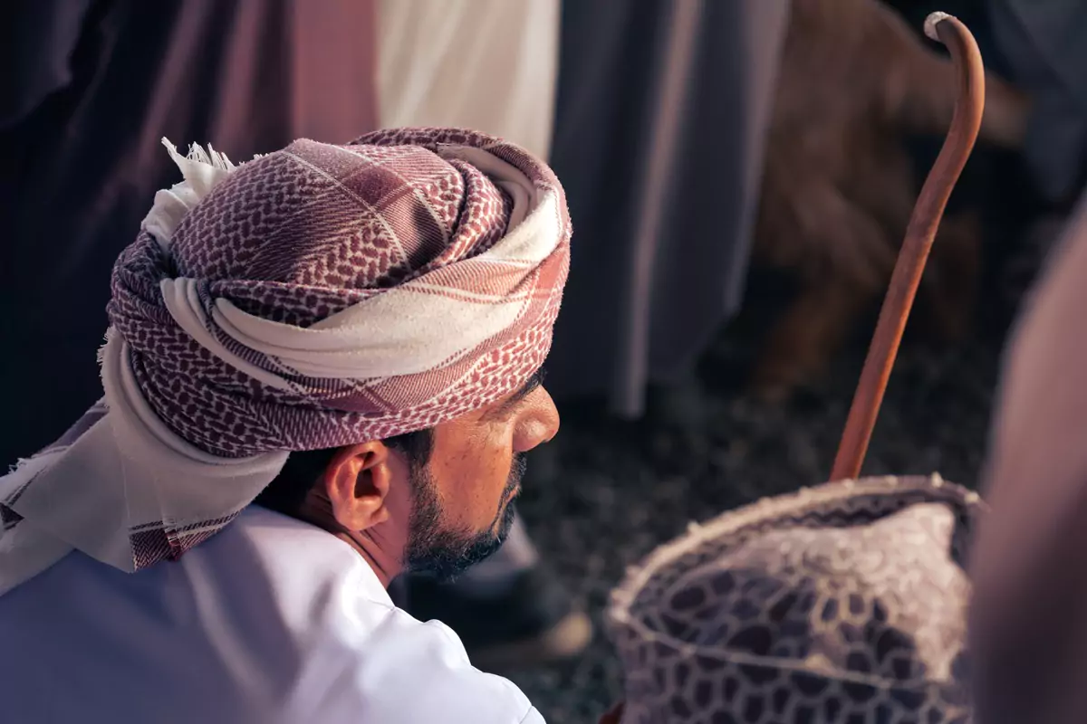 An Omani shepherd, with traditional clothing, waiting to bid at the Nizwa goat market in Oman.