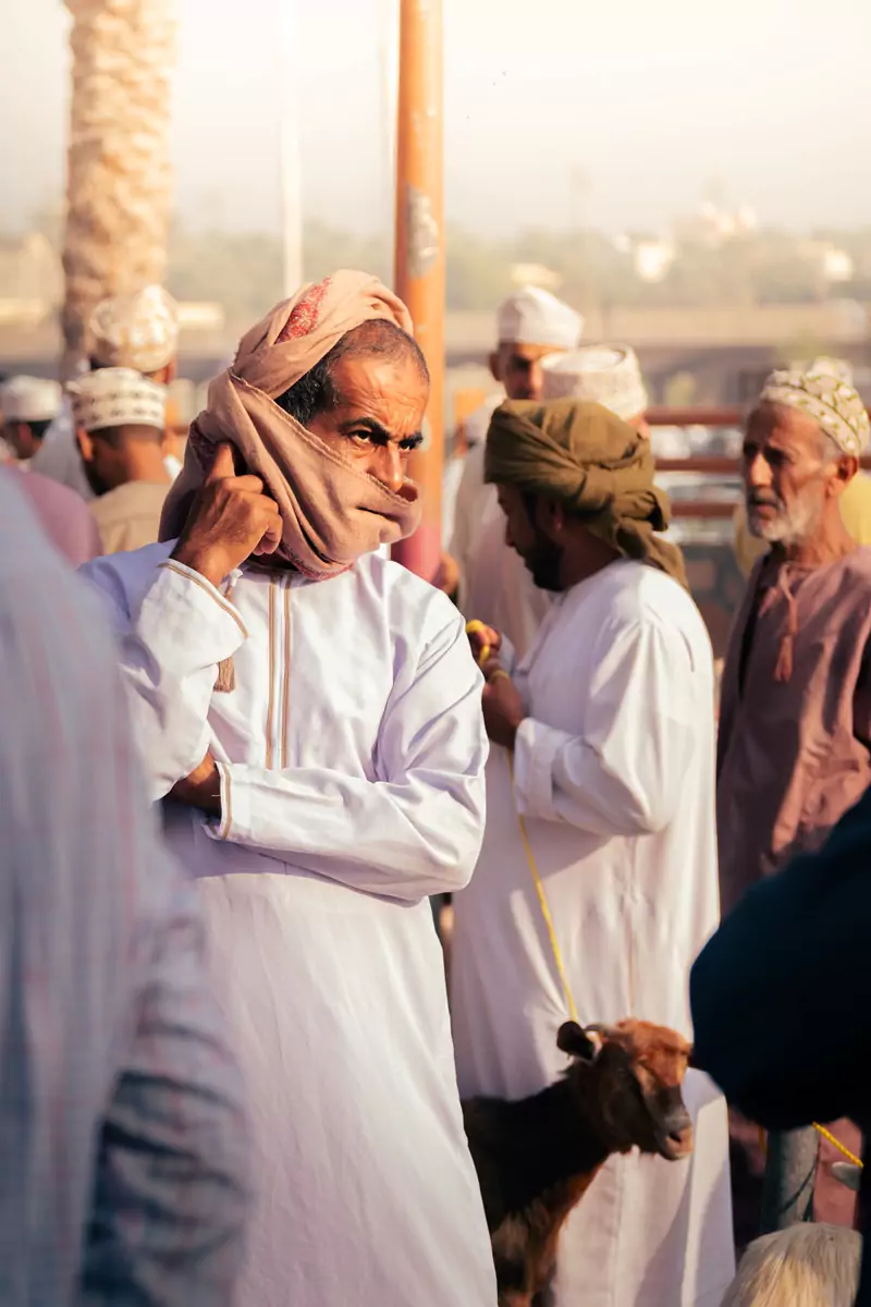 An Omani man watching the goats on parade at the Nizwa goat market in Oman.