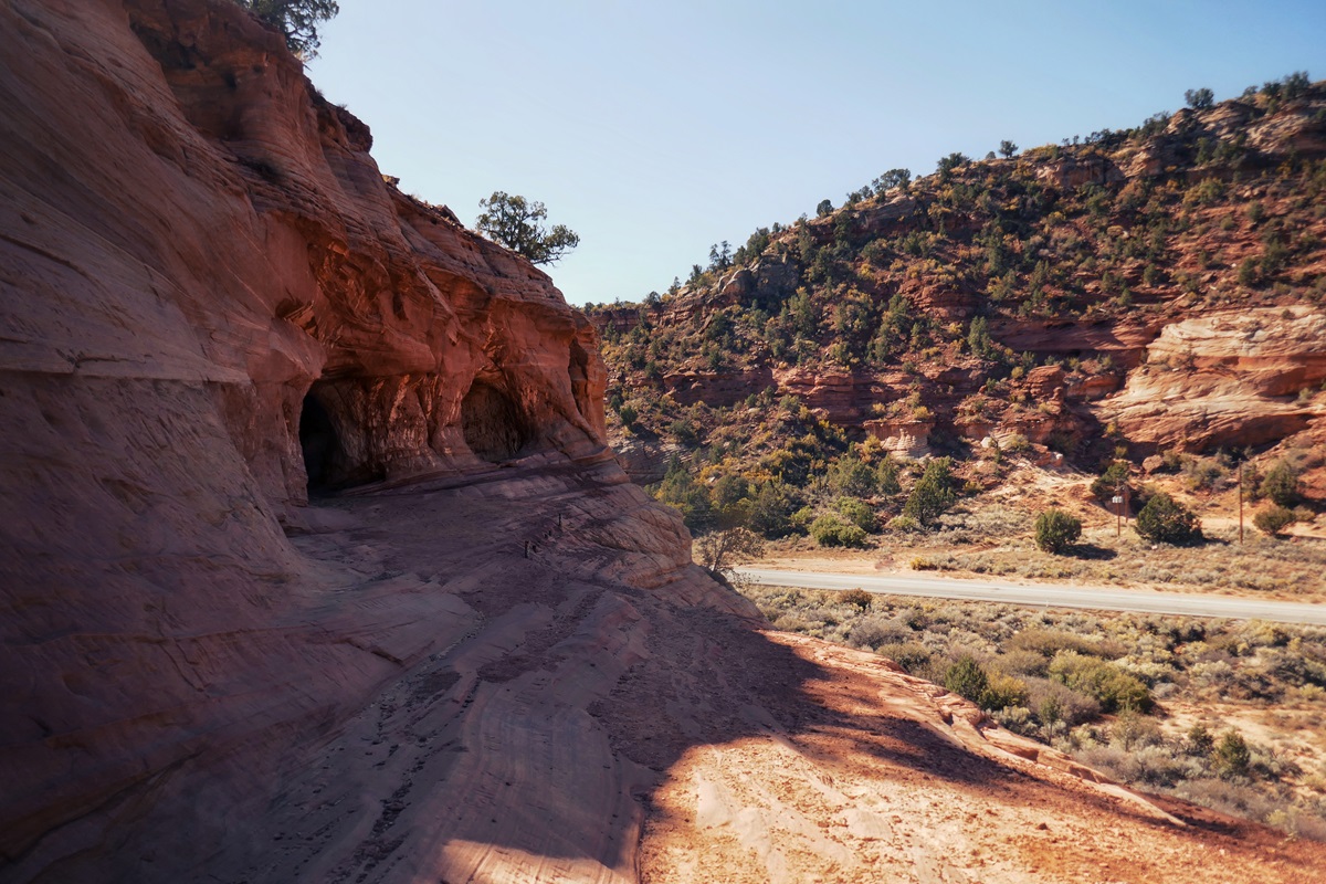 View of the rocky slope to the entrance of the caves above the road.
