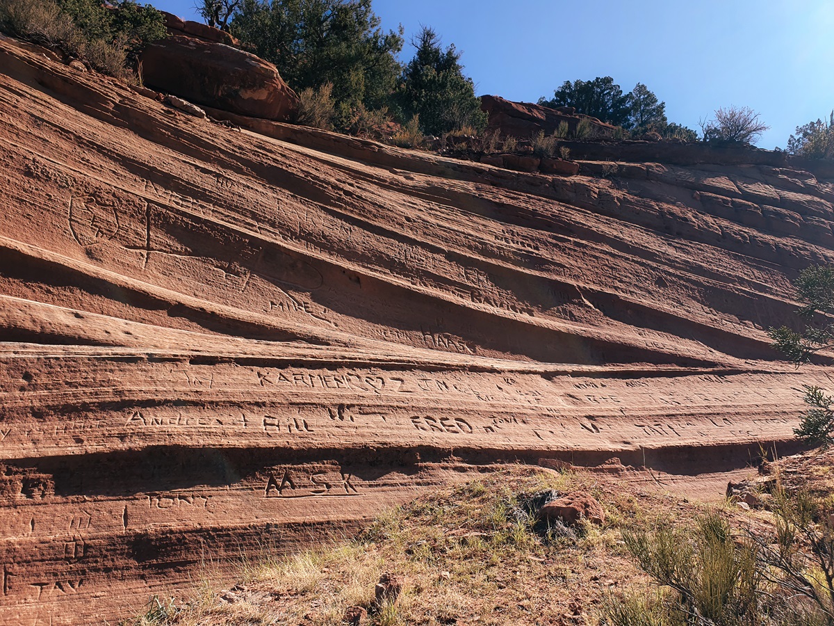 Graffiti carved in the sandstone rock on the climb up to the Kanab Sand Caves.