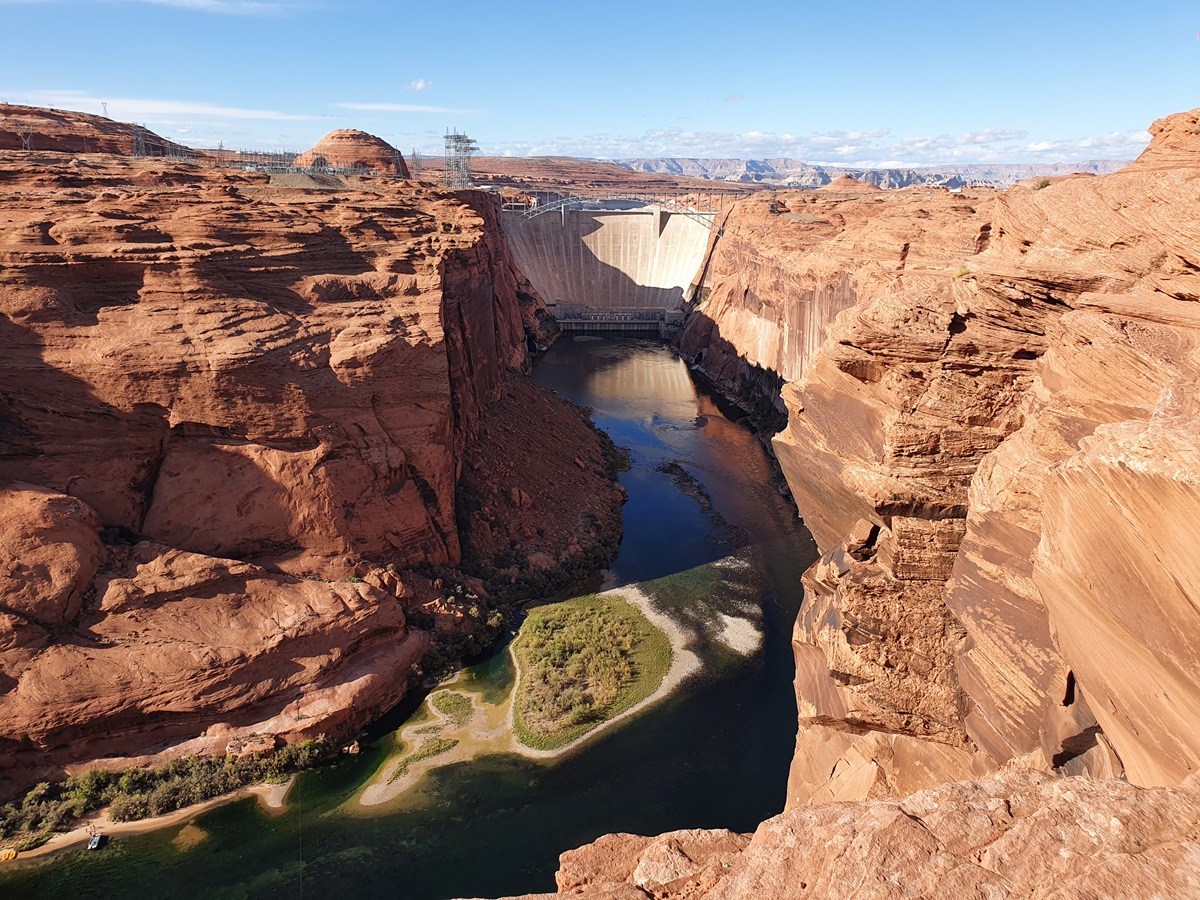 View of the orange canyon walls and waters far below from Glen Canyon Dam Overlook.