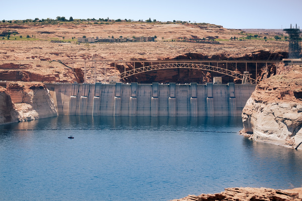 Views of the deep blue waters at Glen Canyon Dam with the city of Page in the distance.