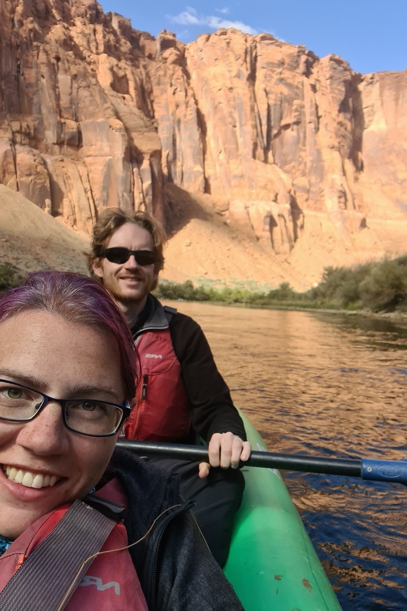 Kayaking Horseshoe Bend in a green kayak with blues skies overhead