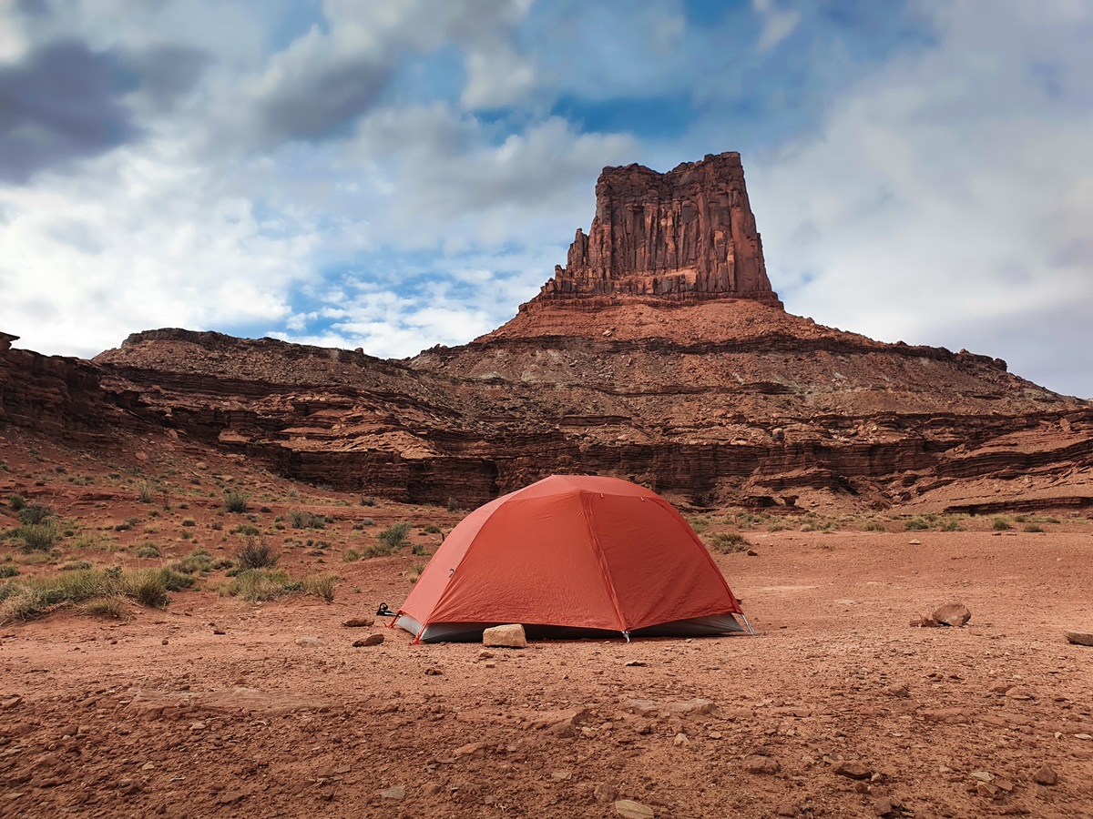 An orange tent at Airport D below the eponymous rock structure in Canyonlands National Park.