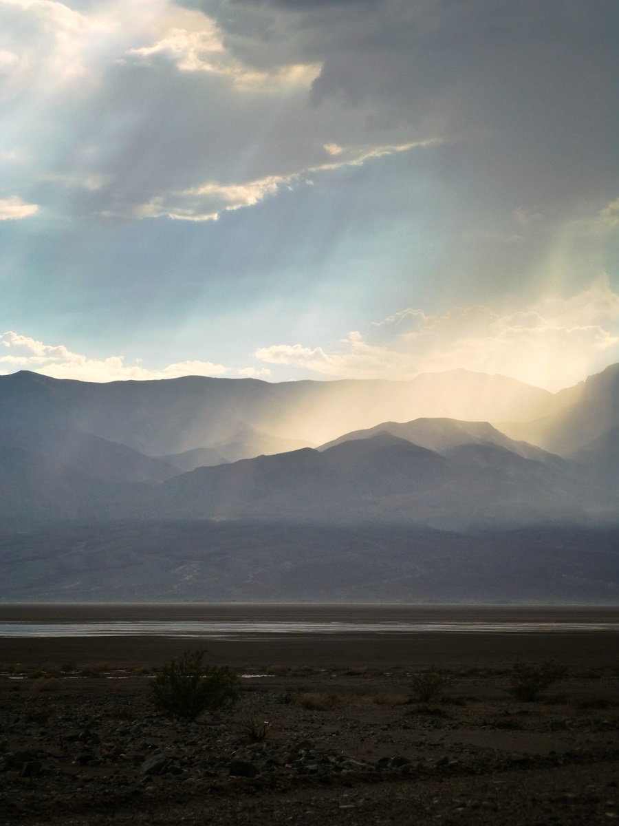 Sunlight breaking through rain clouds in Death Valley.