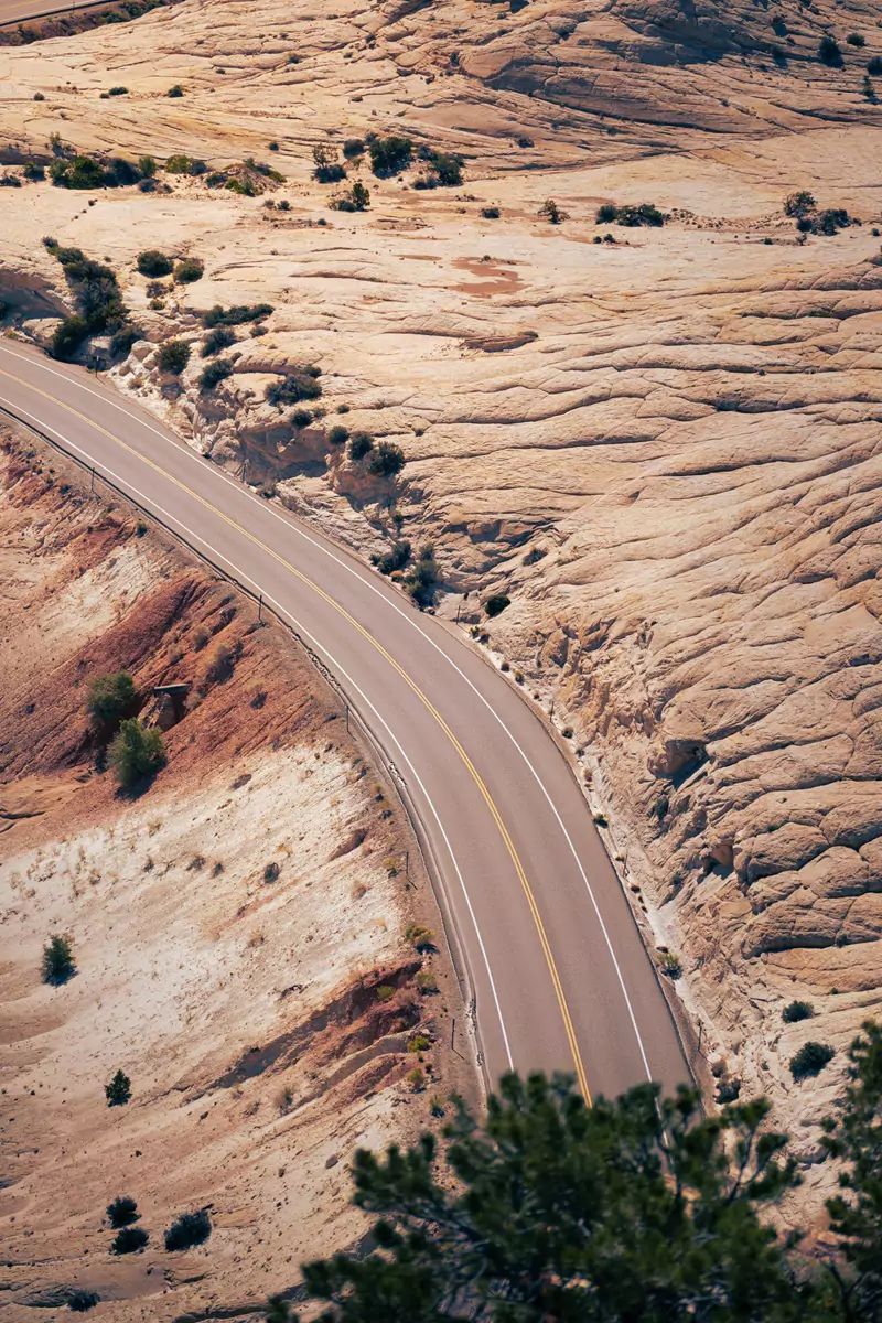 Part of the paved Scenic Byway-12 curving over white limestone rock.