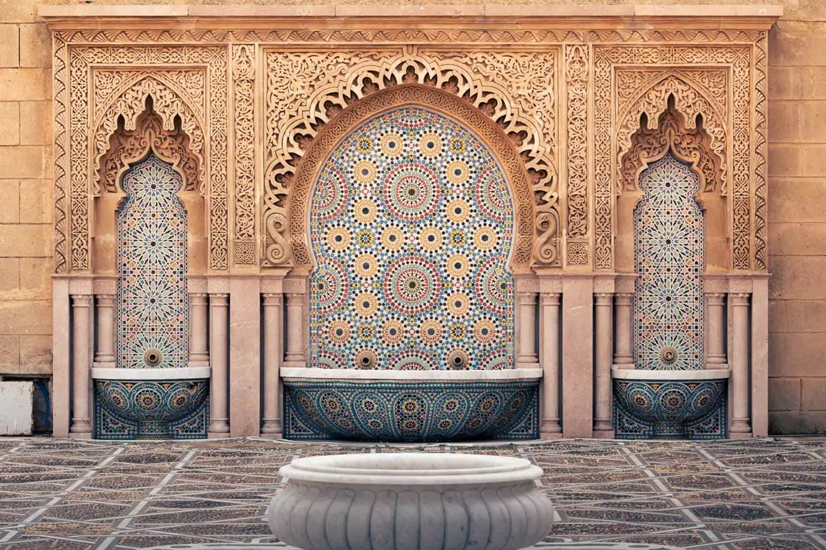 Intricate zellij tilework and stucco plasterwork at a fountain outside the Mausoleum of Mohammed V in Rabat, Morocco.