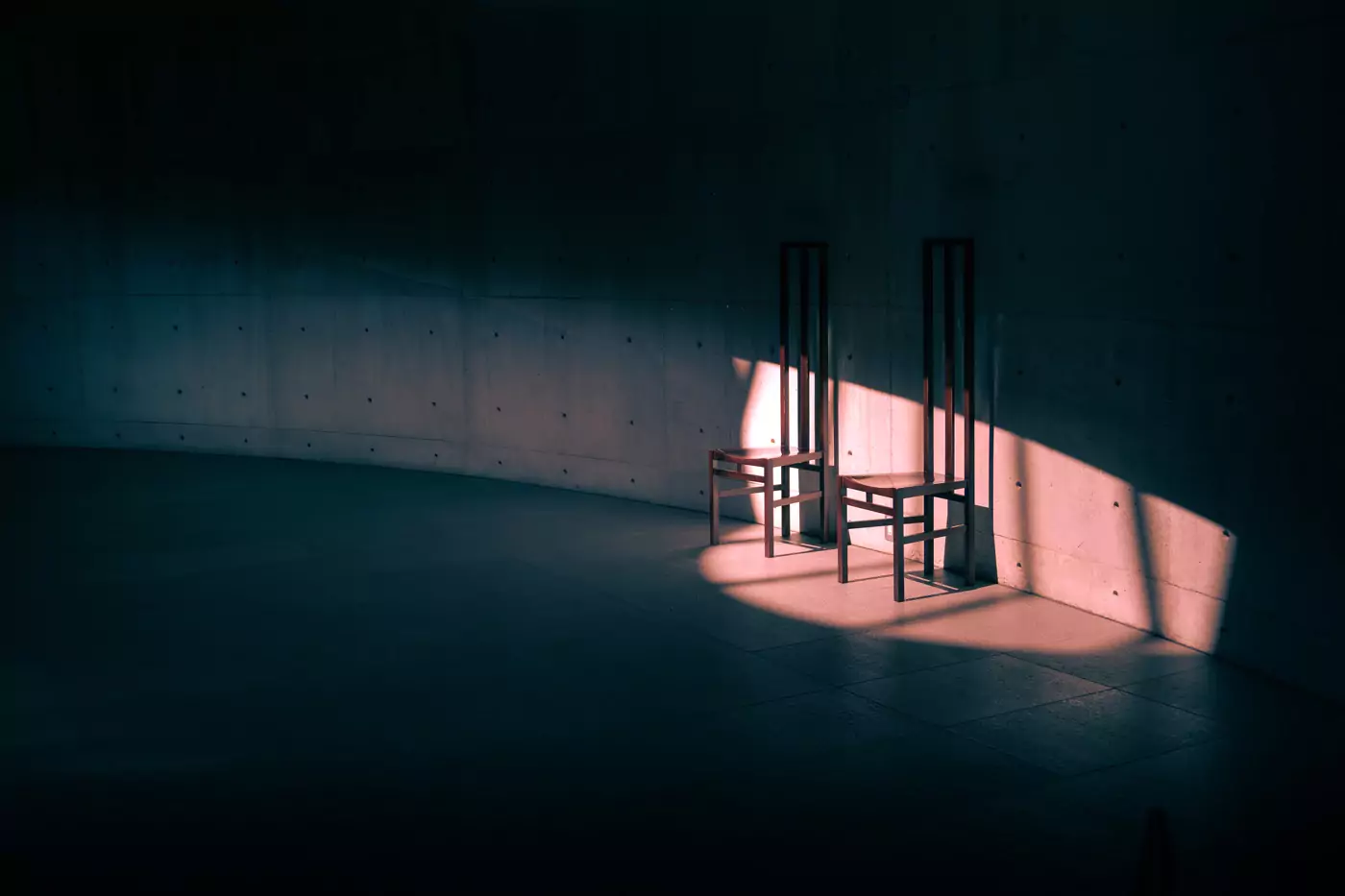 Sunlight from a window lighting up parts of two wooden chairs inside an art museum on Naoshima Island, Japan.