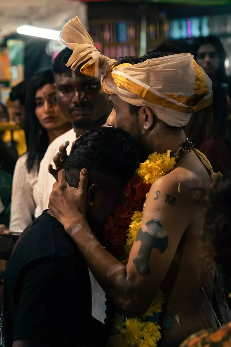 One devotee, wearing a garland of yellow flowers, embracing another during the Thaipusam celebrations at the Batu Caves in Kuala Lumpur.