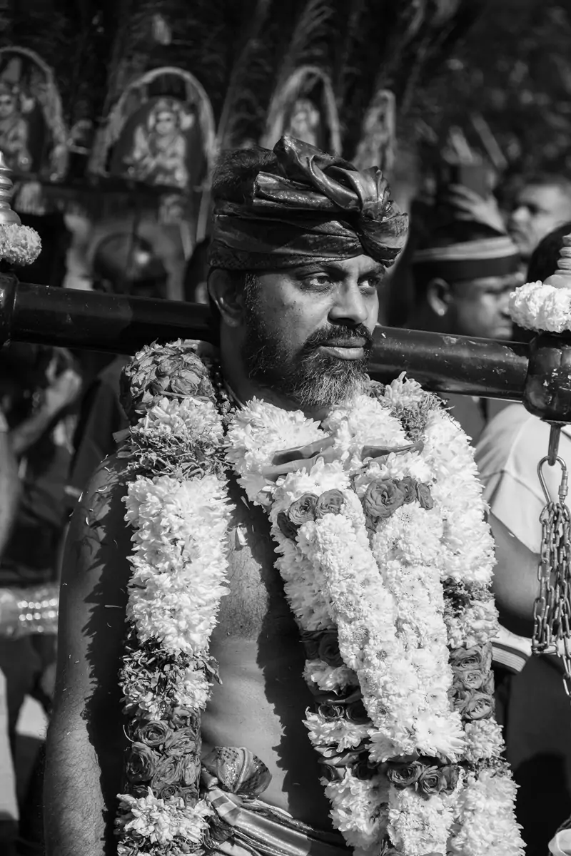A kavadi wearer with flower garlands around their neck.