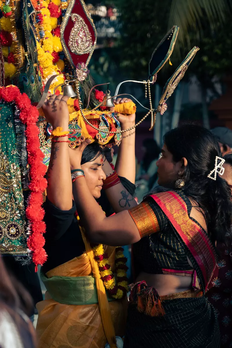 One of a kavadi wearer's entourage helping to re-adjust the kavadi at the Thaipusam festival in Kuala Lumpur's Batu Caves.