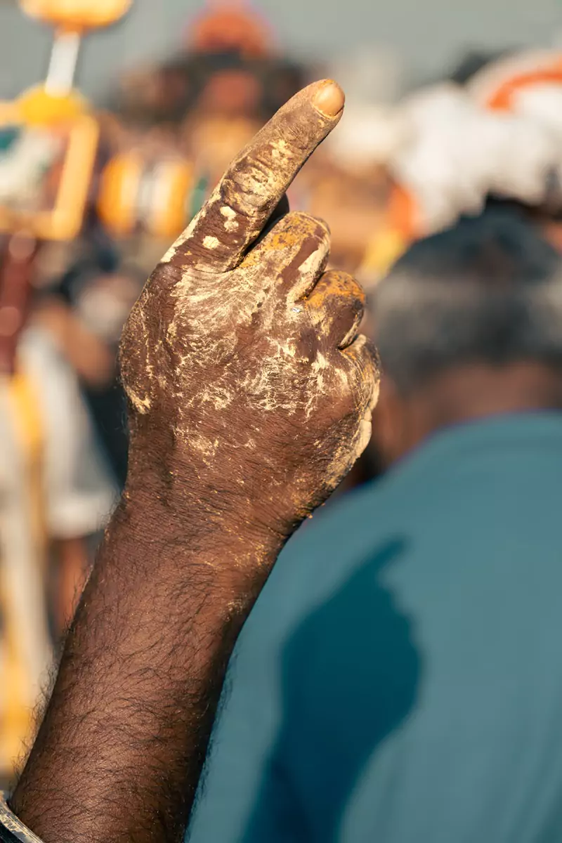 A hand covered in yellow sandalwood paste at the Thaipusam festival in Kuala Lumpur's Batu Caves.