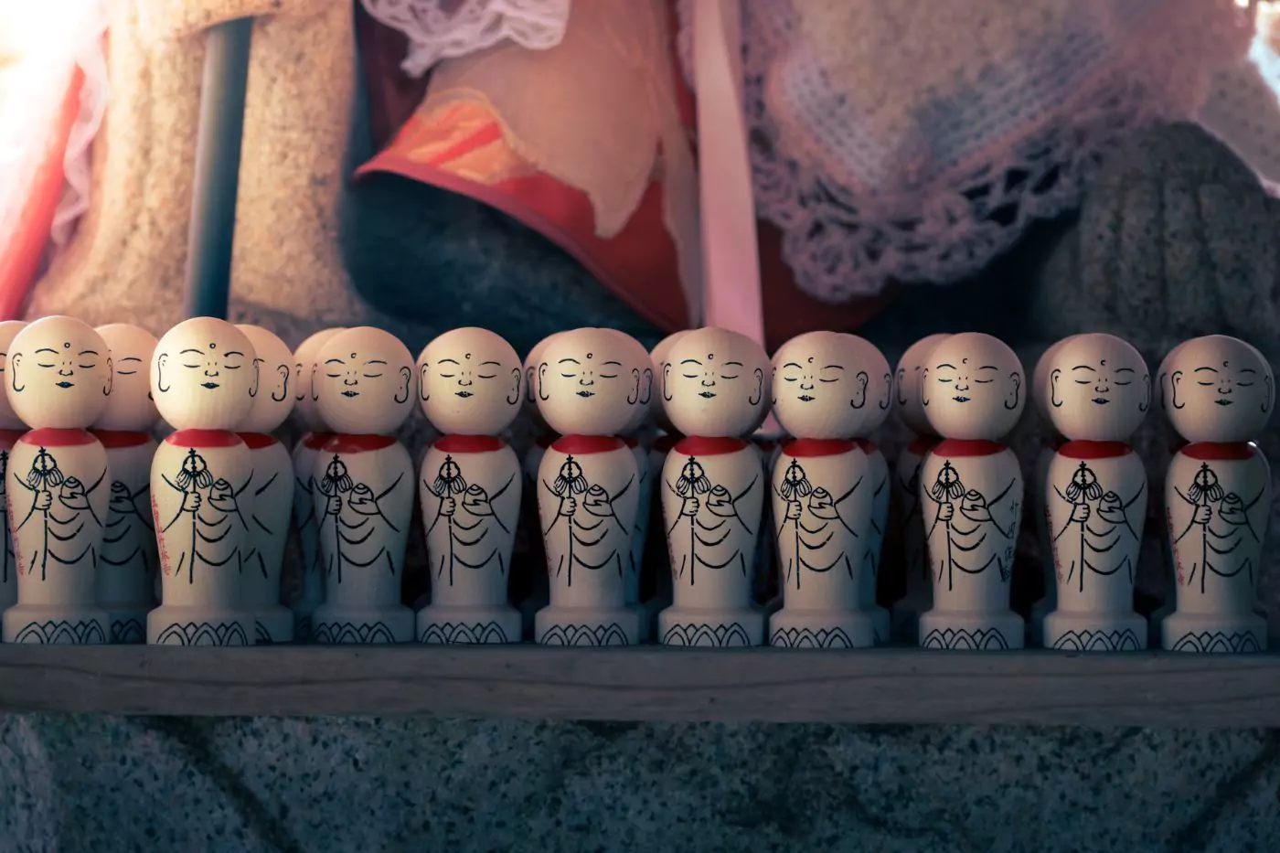 Rows of carved wooden figurines at a shrine in Japan.