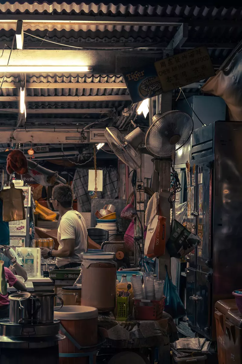 The inside of a busy and hot street-food market at night in George Town, Penang.