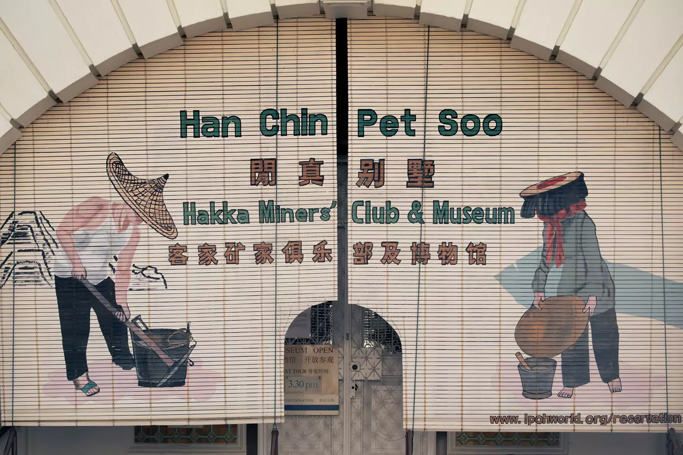 Ornate mural above the entrance to the Hakka Miners Club and Museum in Ipoh, Malaysia. The mural features tin workers wearing traditional clothing.