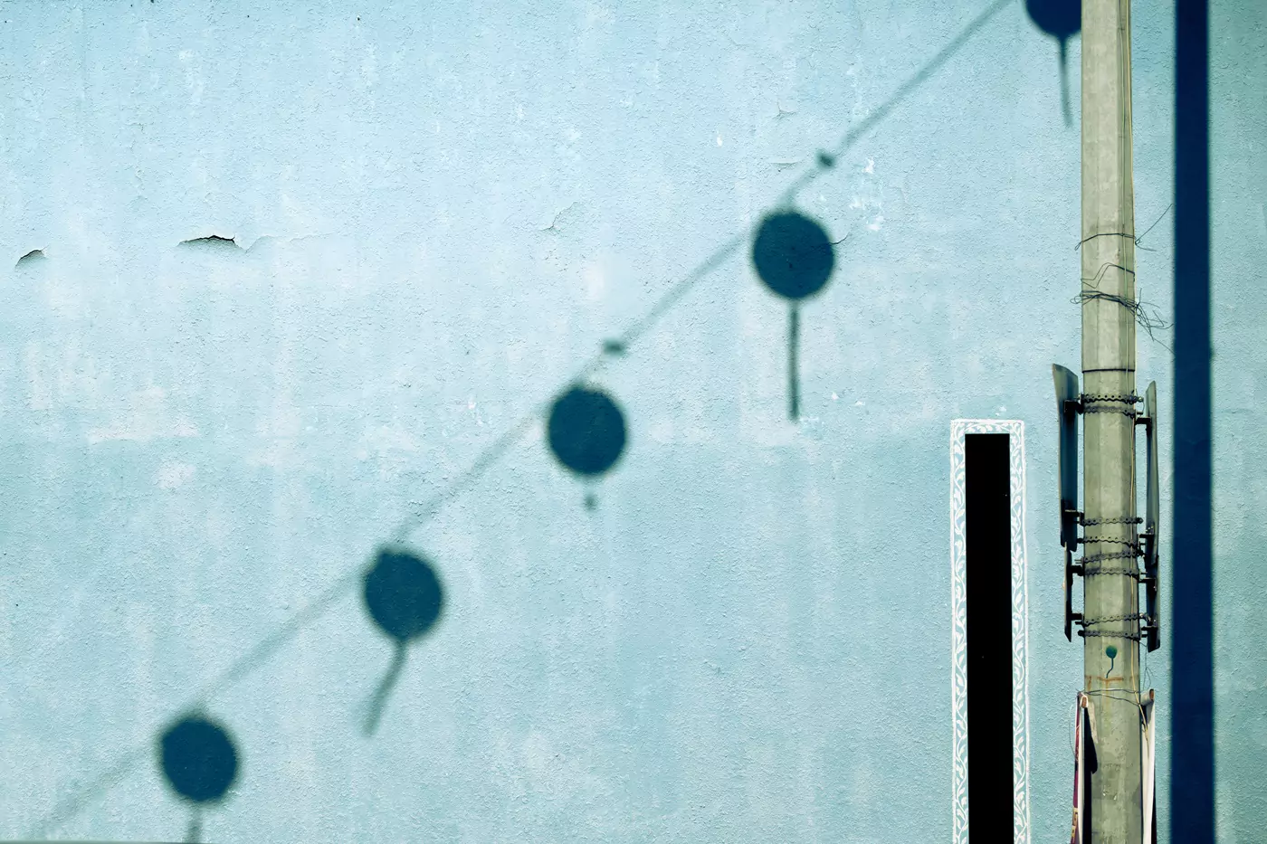Shadows of Chinese Lanterns on a wall in Ipoh, Malaysia, looking like tied balloons on a wire,